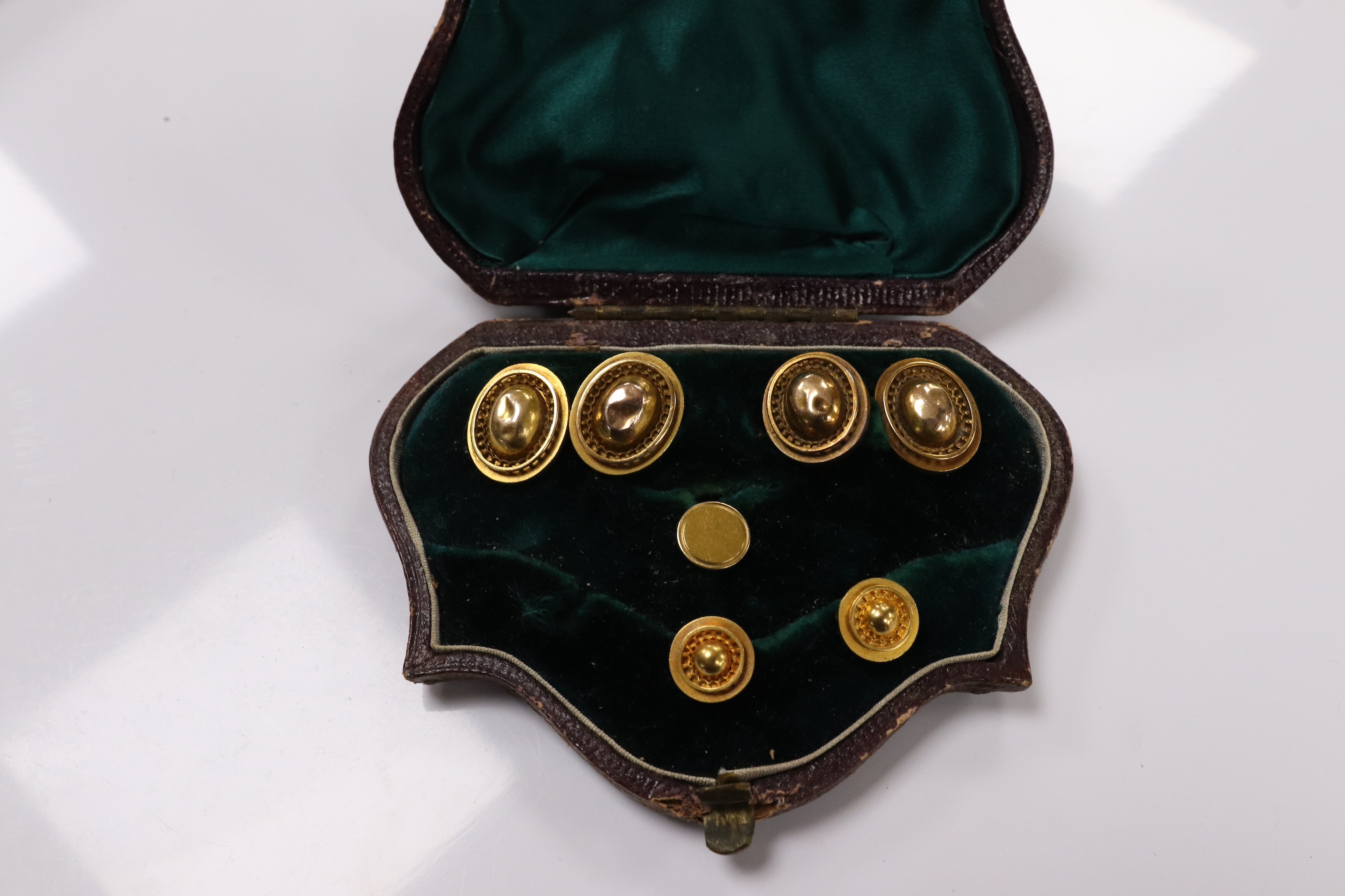 A pair of yellow metal oval cufflinks and three similar dress studs, one stamped 18, gross weight 10.8 grams. Condition - poor